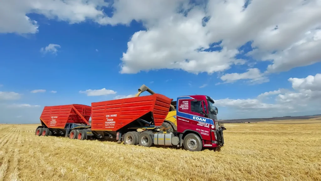 Edan Vehicle & Asset Hire truck with interlink bottom dumper trailers during grain harvesting in South Africa.