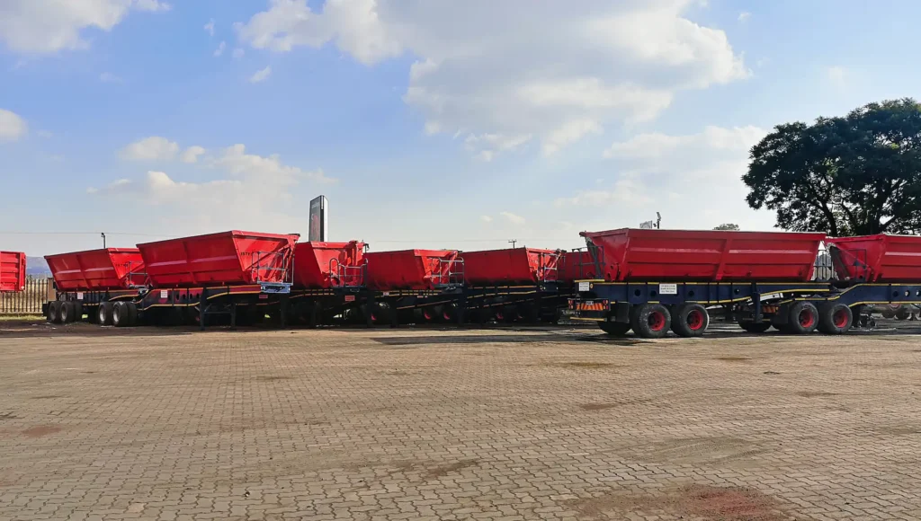 Row of red interlink side tipper trailers available for hire from Edan Vehicle and Asset Hire.