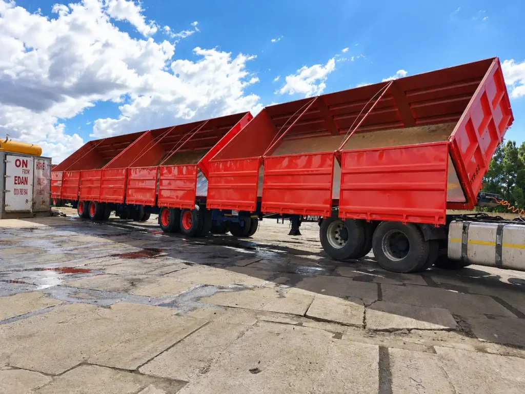 Superlink dropside tipper trailer and truck with the tipping body raised in an industrial yard.