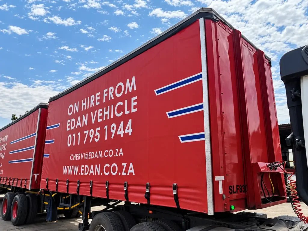 Red tautliner trailer for hire from Edan Vehicle & Asset Hire, showing the curtain-sided body and rear loading area.