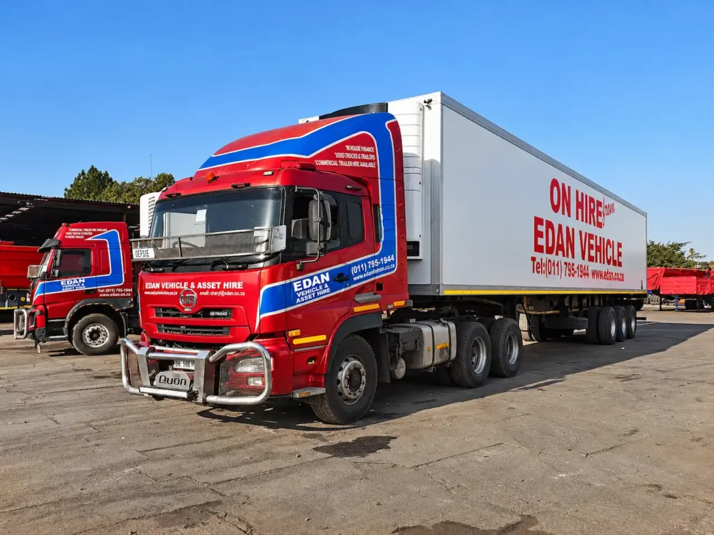 UD Quon truck attached to a white triaxle refrigerated trailer with Edan Vehicle & Asset Hire branding, parked in the company's commercial vehicle yard.